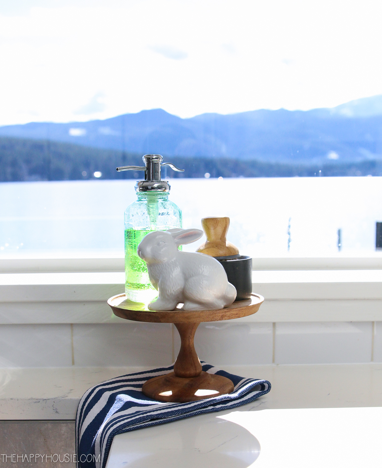 A wooden stand with a white bunny and dish soap by the sink.