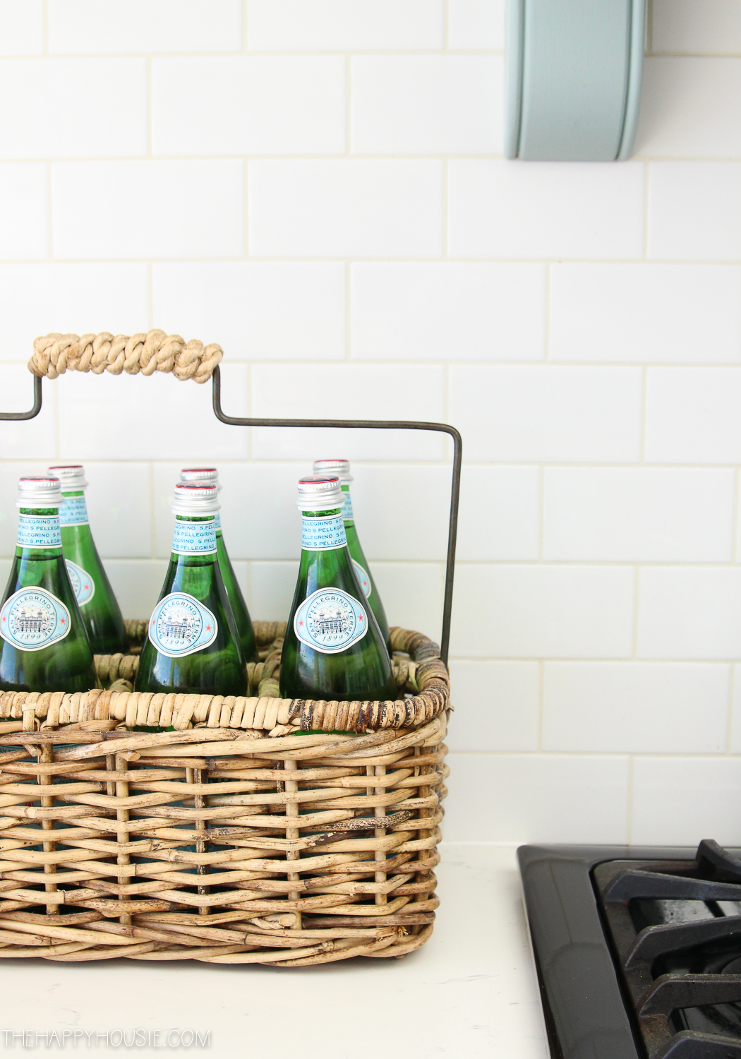 A wicker basket full of Pellegrino on the counter.