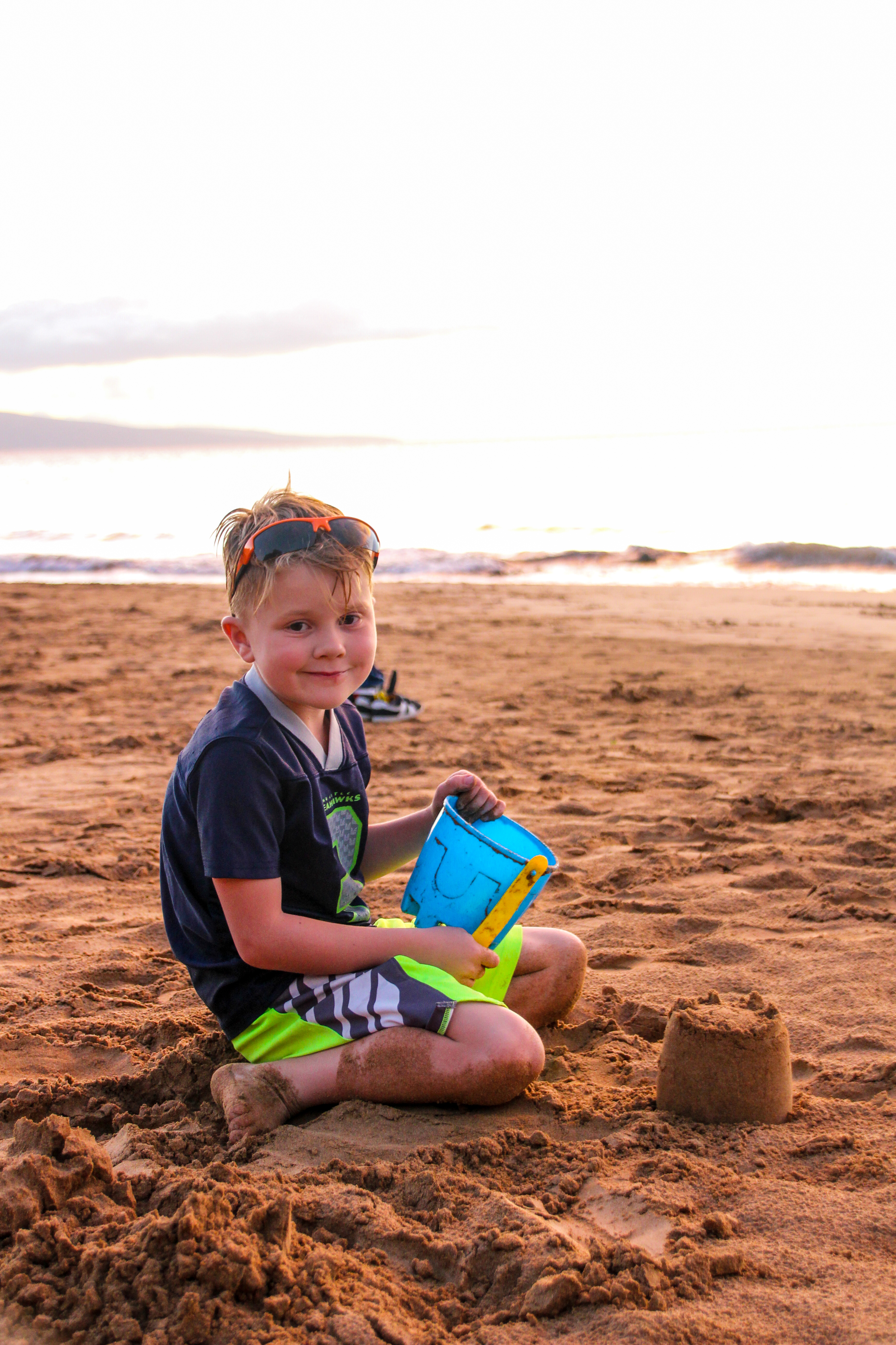 A boy building a sand castle.