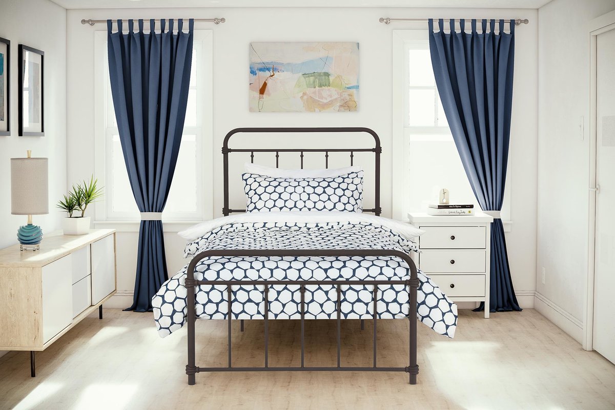A mostly white bedroom with blue curtains and a blue and white bedspread.