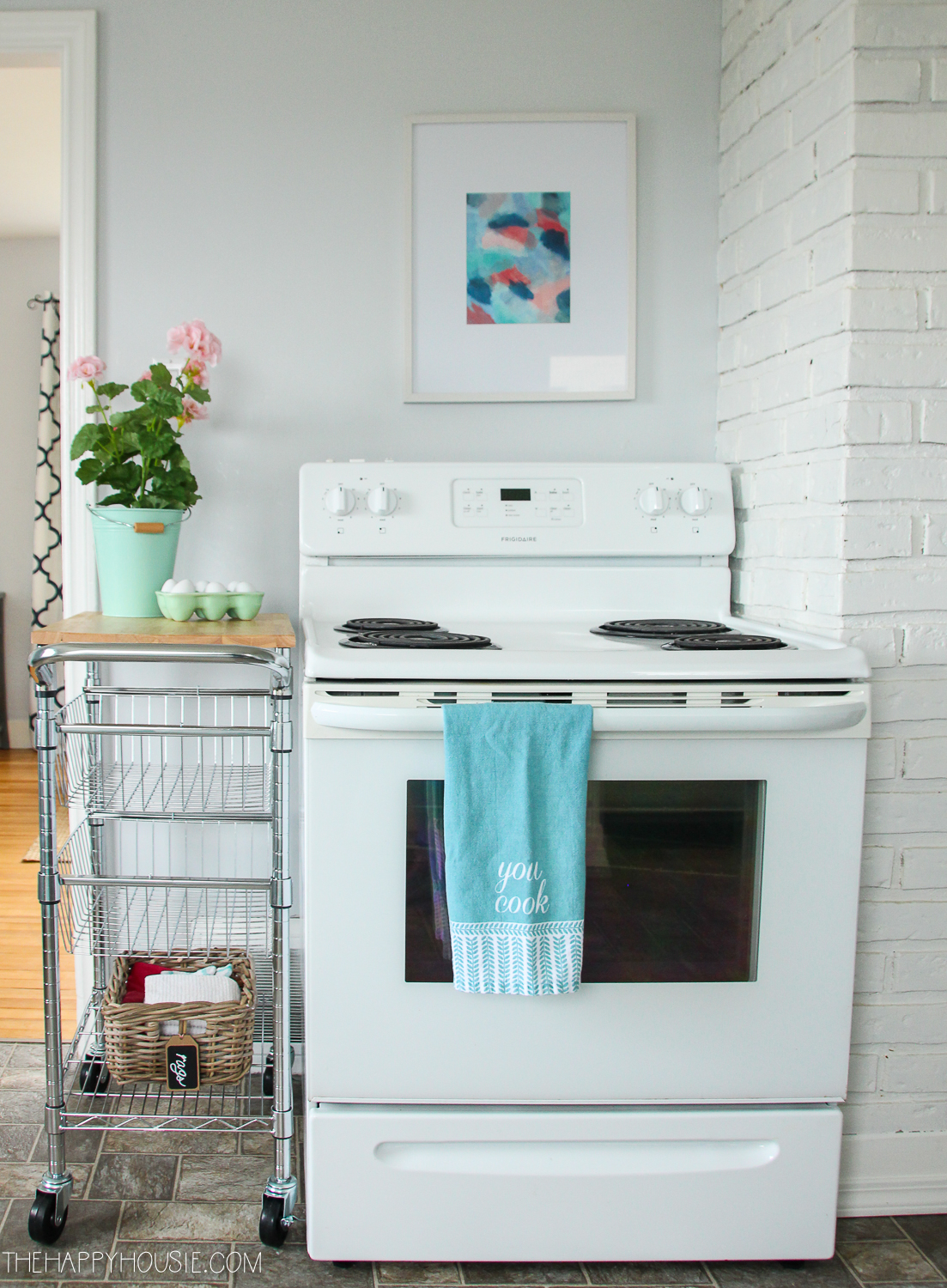 A white stove is in the corner of the kitchen.