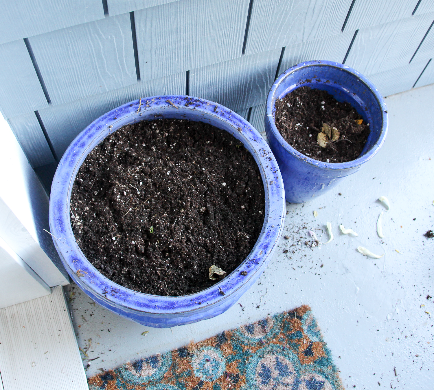 The pots with soil in them on the front porch.