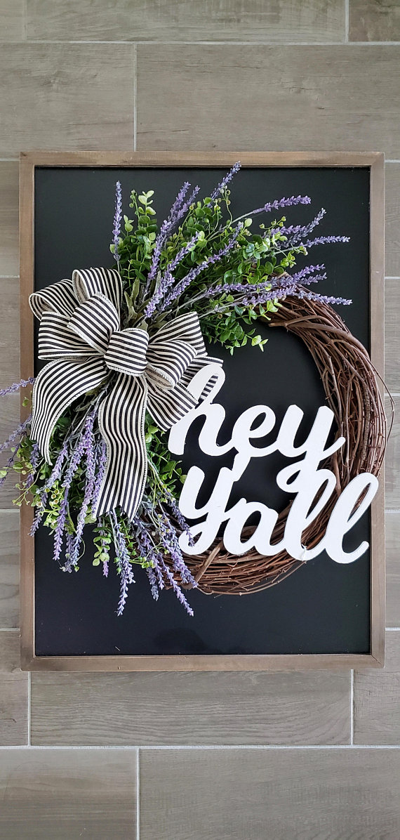 A twig wreath with lavender and a large striped bow on it.
