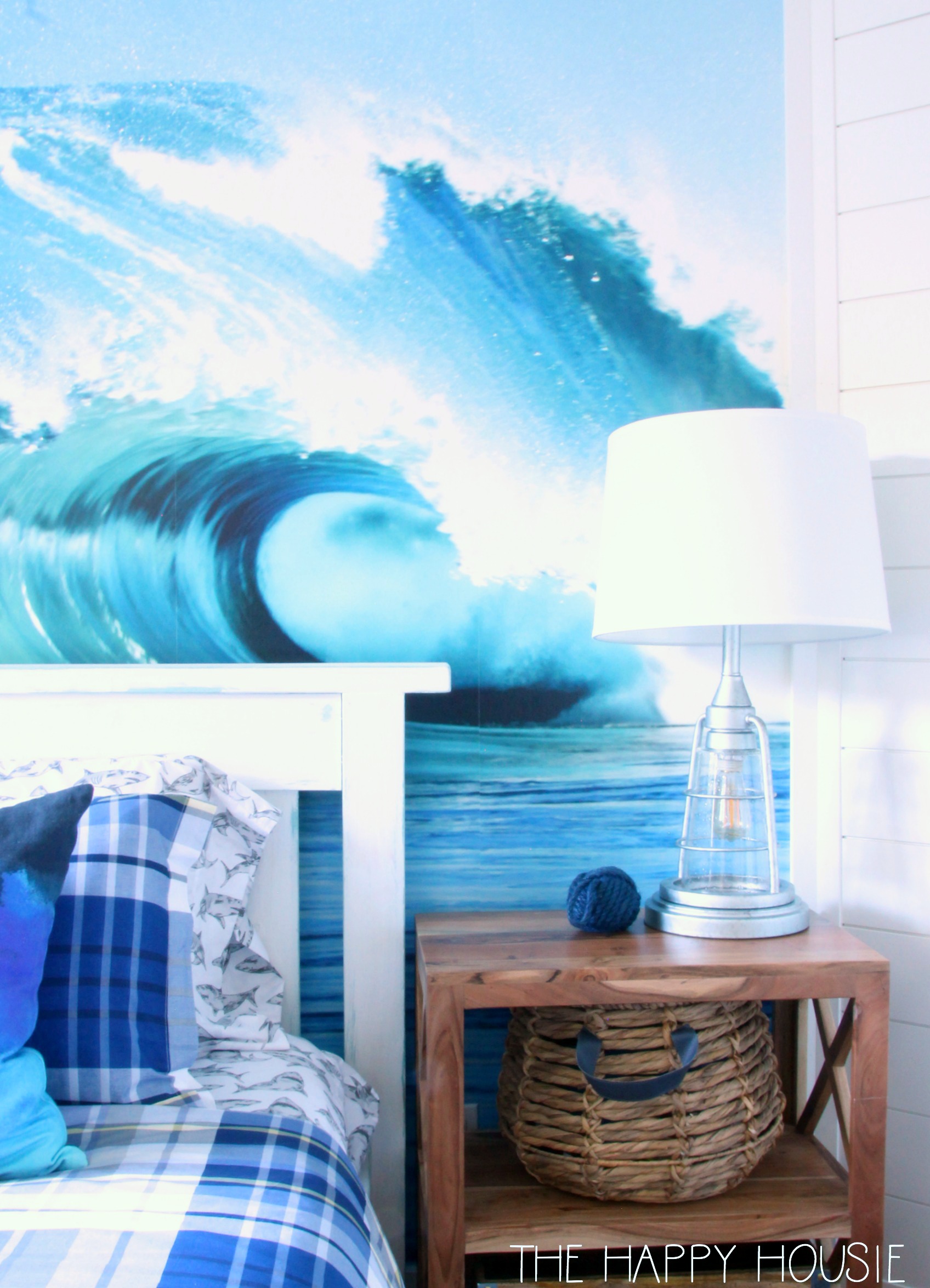 A surf mural on the wall with a lamp in front of it.