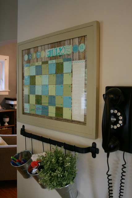 A homemade calendar on the wall with a phone beside it.