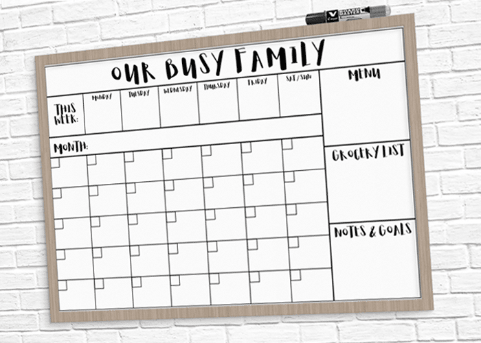 Our Busy Family Calendar that is white and framed in wood.