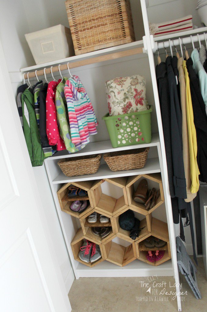 An opened closet revealing wooden slots for shoes.