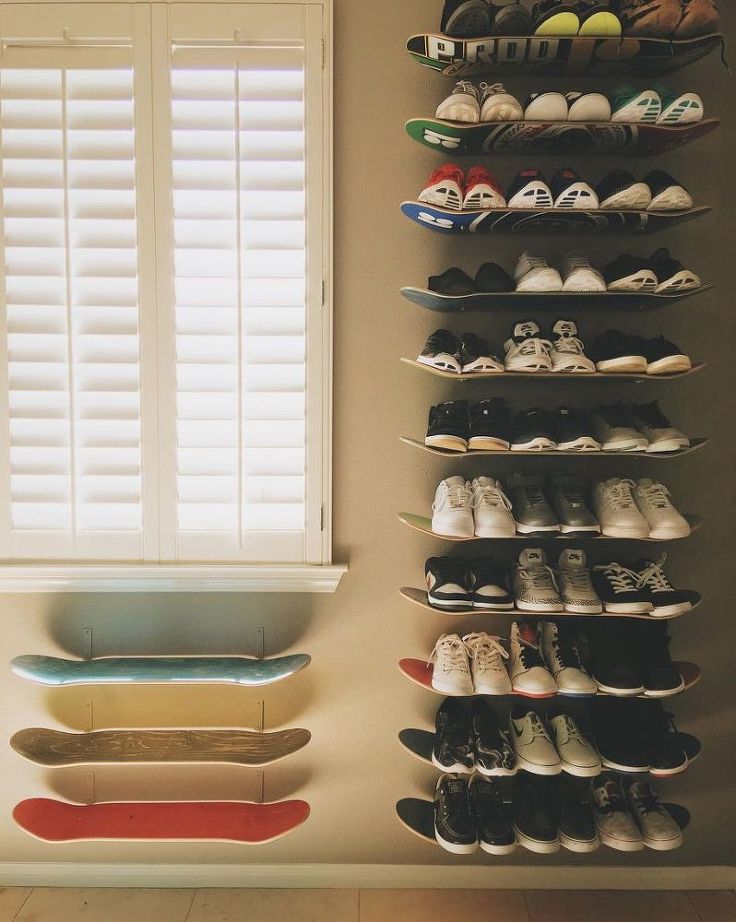 skateboards attached to the wall with shoes on them.