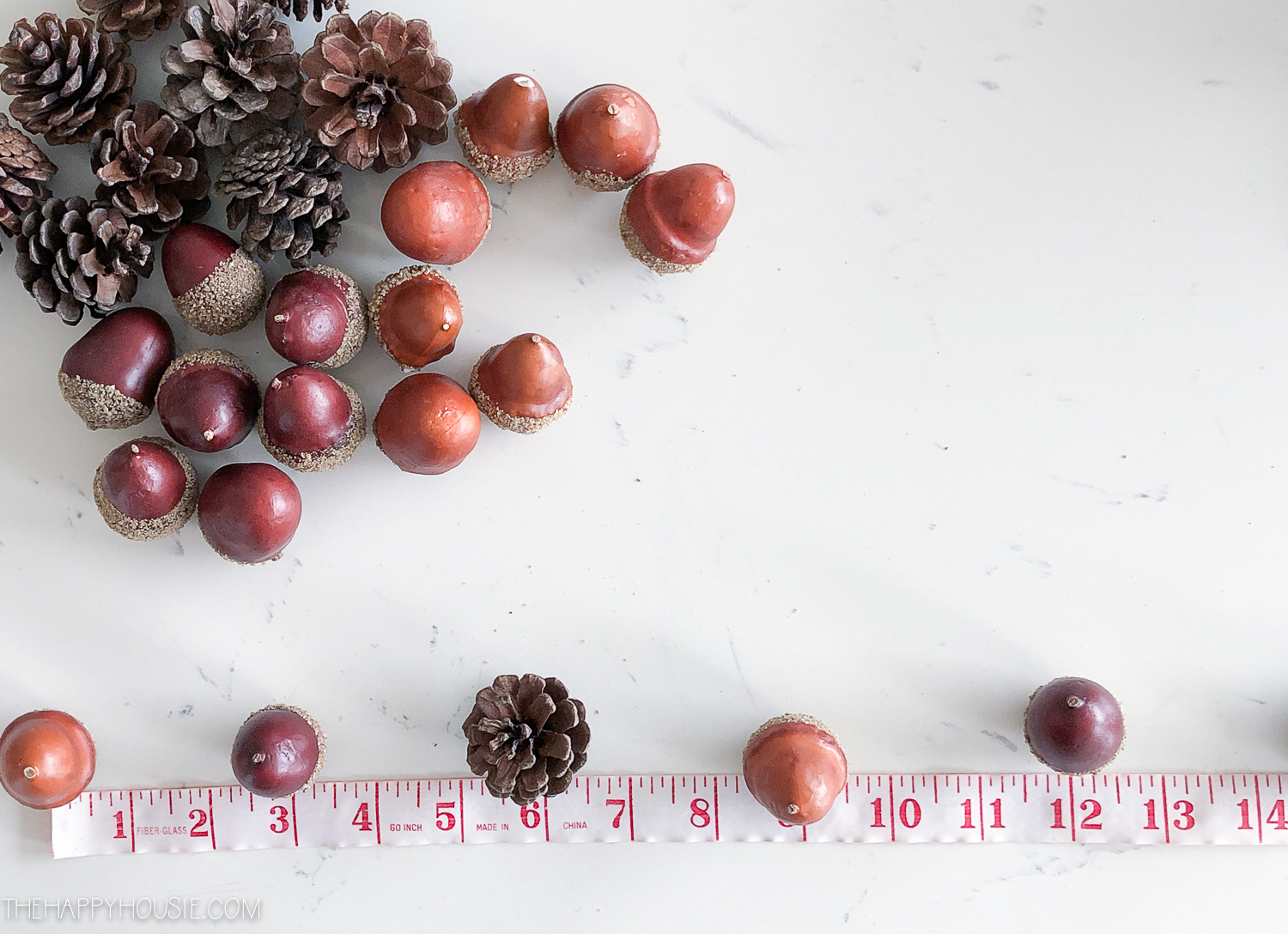 Measuring the acorns and pinecones so they are the same approximate size.