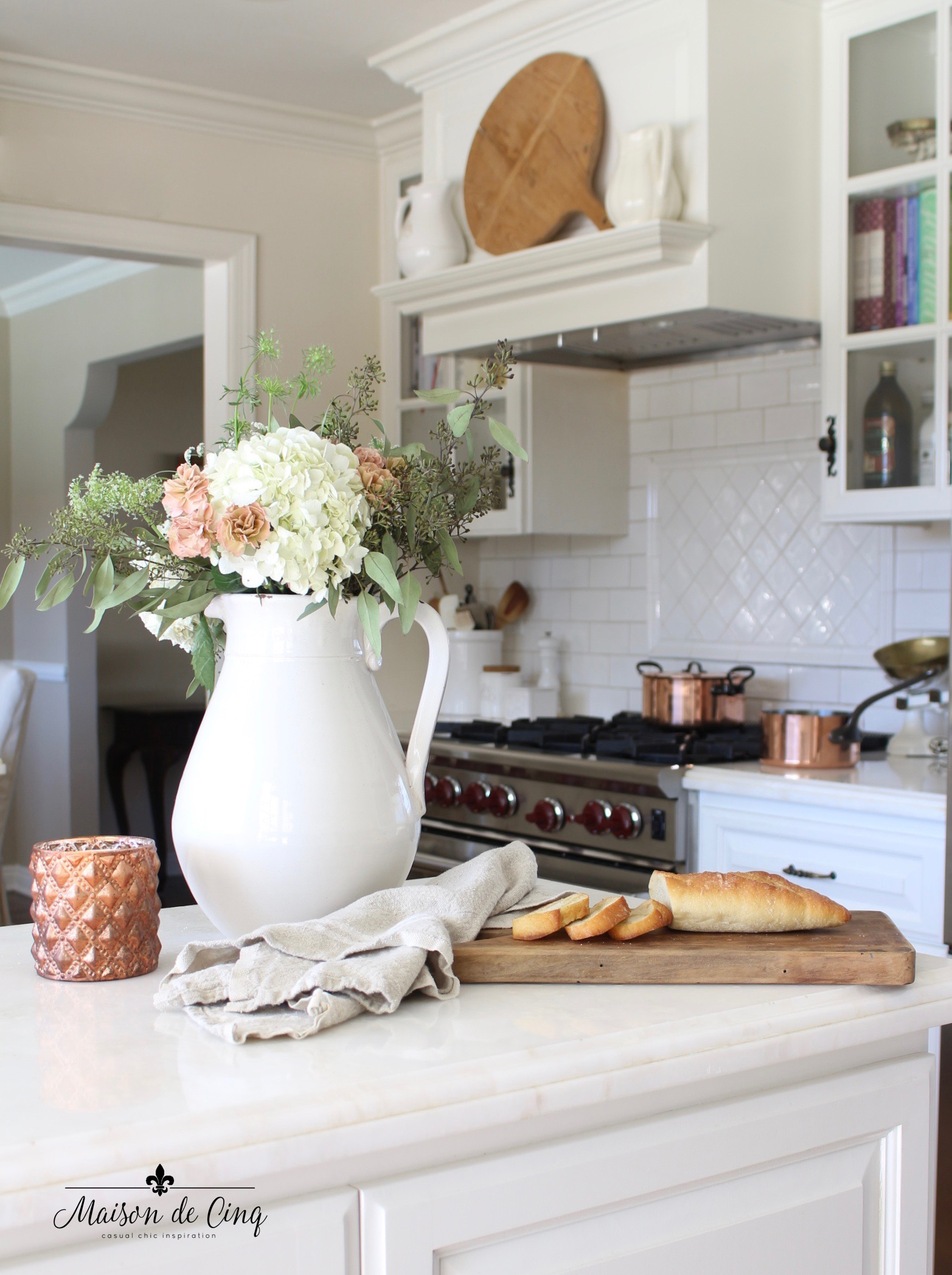 A pitcher filled with flowers on a kitchen island.