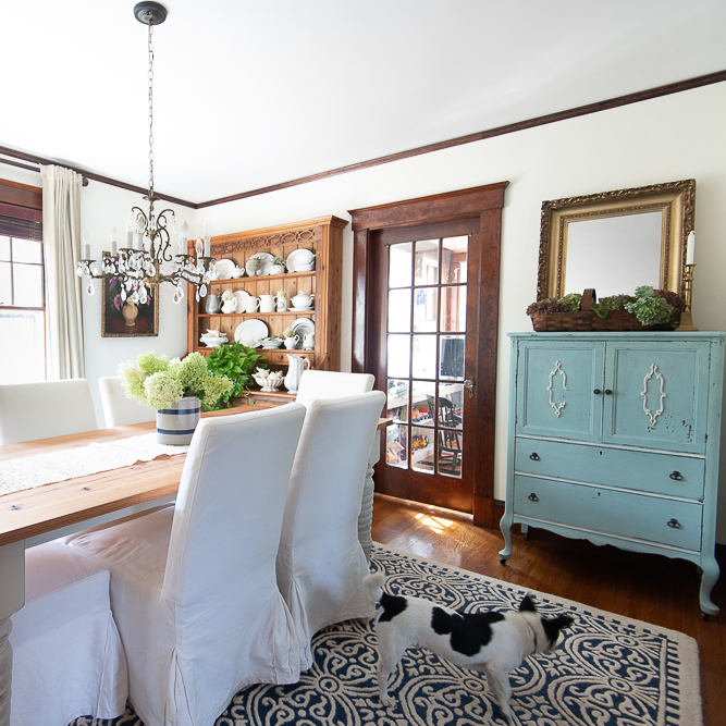 Hydrangeas in a vase is on a wooden table.