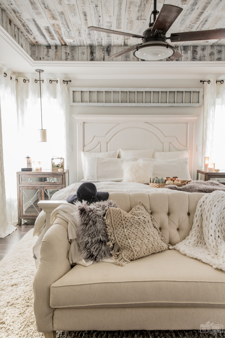 Wooden ceiling, white couch in a bedroom.