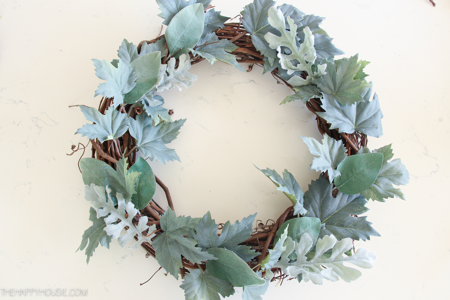 The maple leaves arranged on the grapevine wreath.
