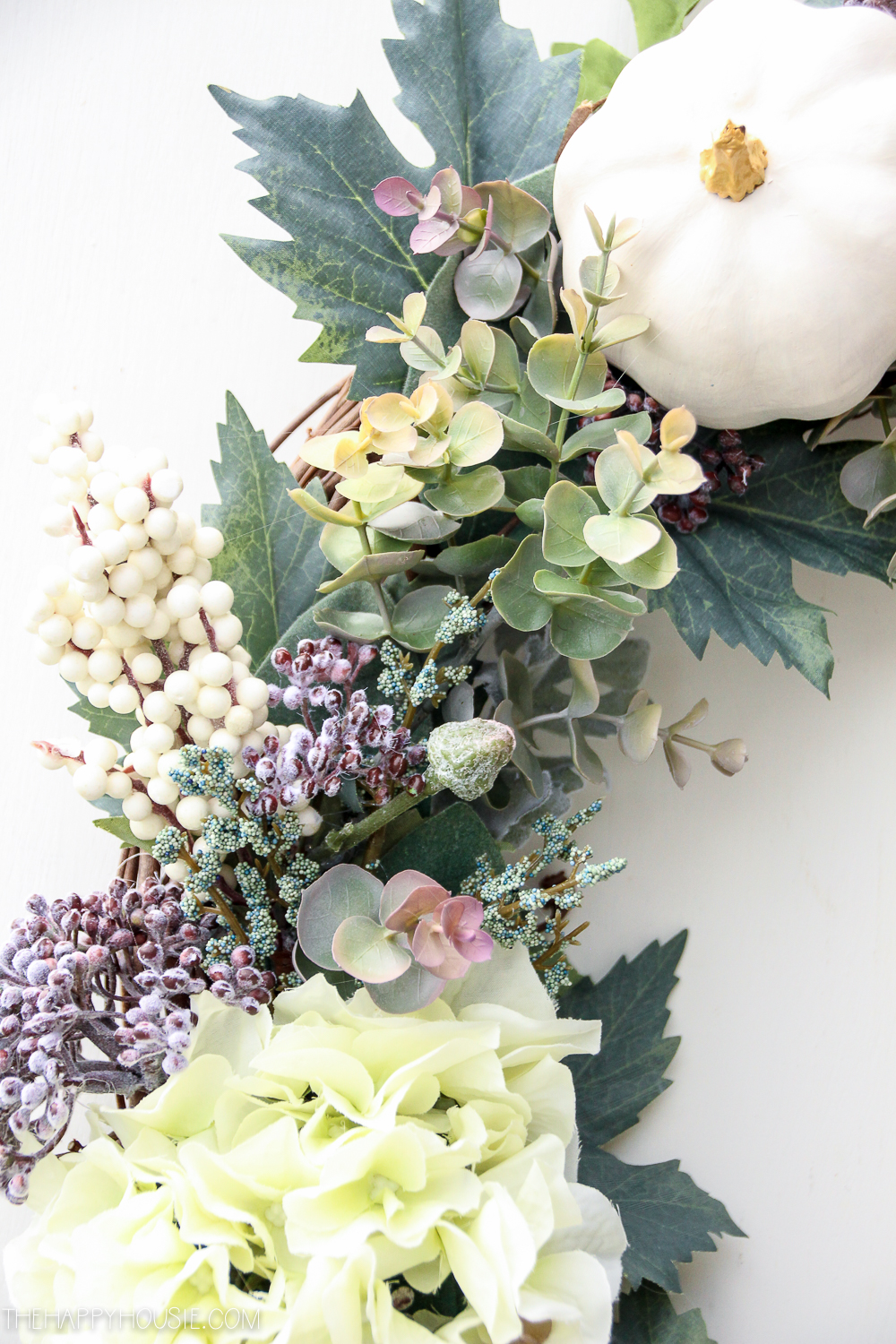Up close of the the berry, eucalyptus and leaves on the wreath.