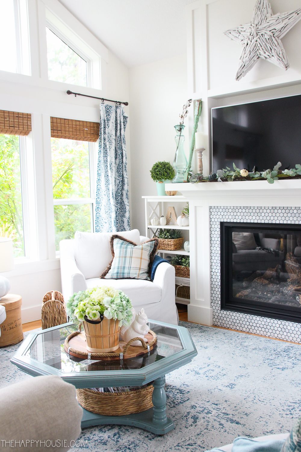A blue tinged coffee table in the living room with a fireplace.