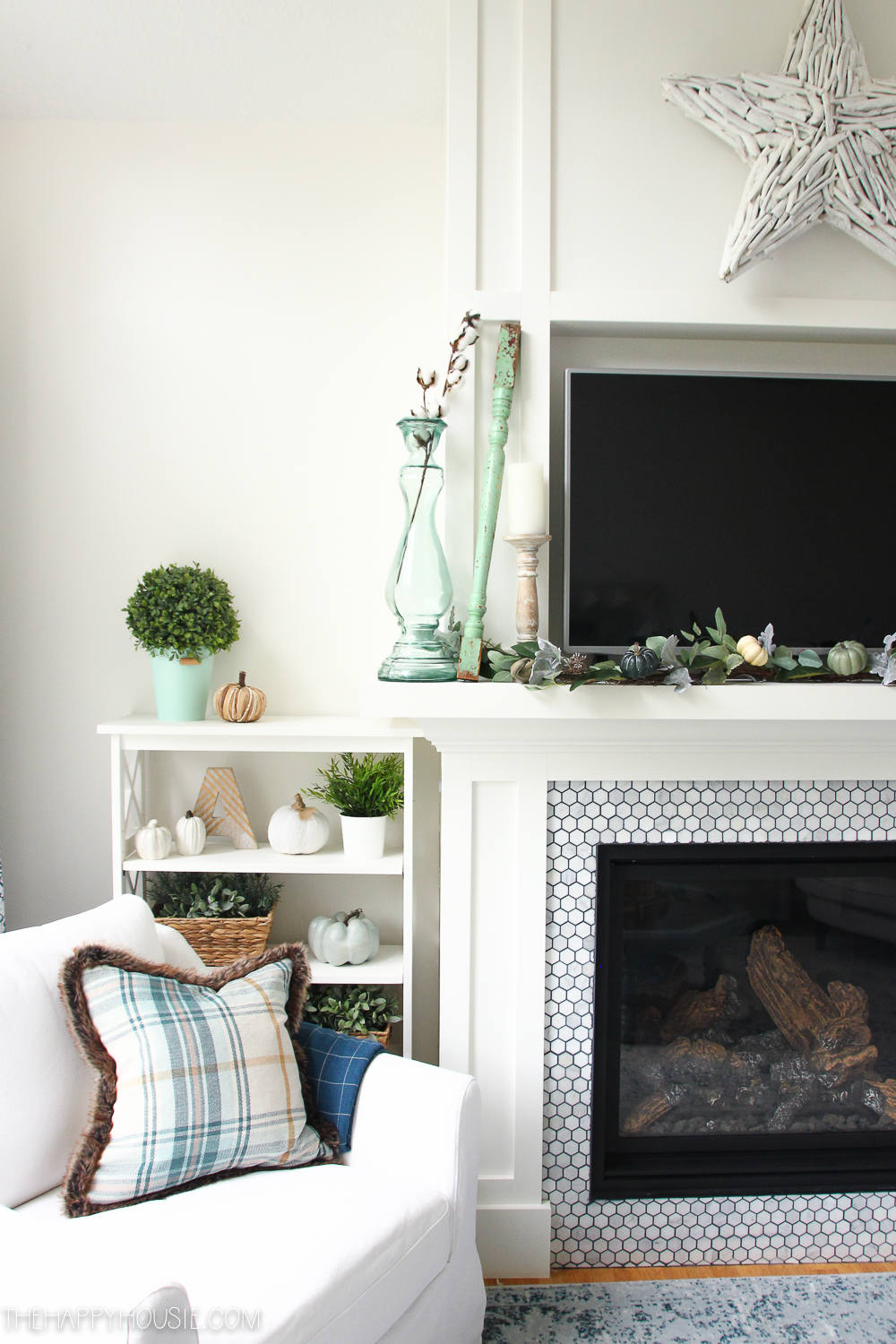 A small shelf beside the fireplace is beside the armchair.