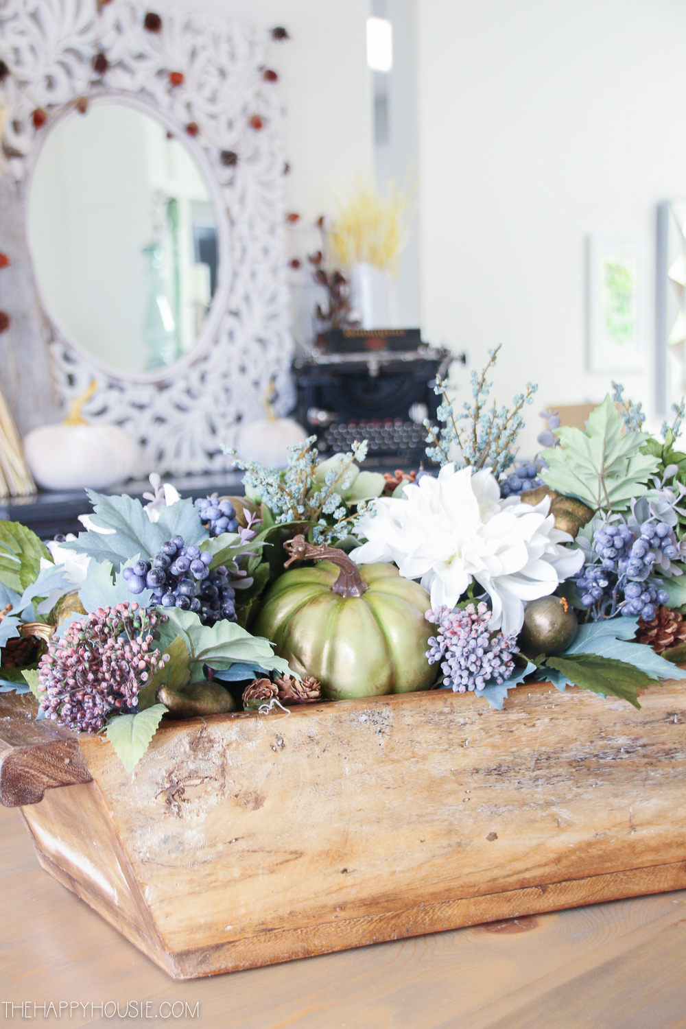 Florals, pumpkins and berry centerpiece on the table.