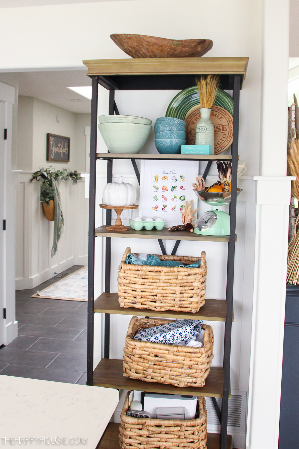 A wooden shelf off the kitchen with wicker baskets.