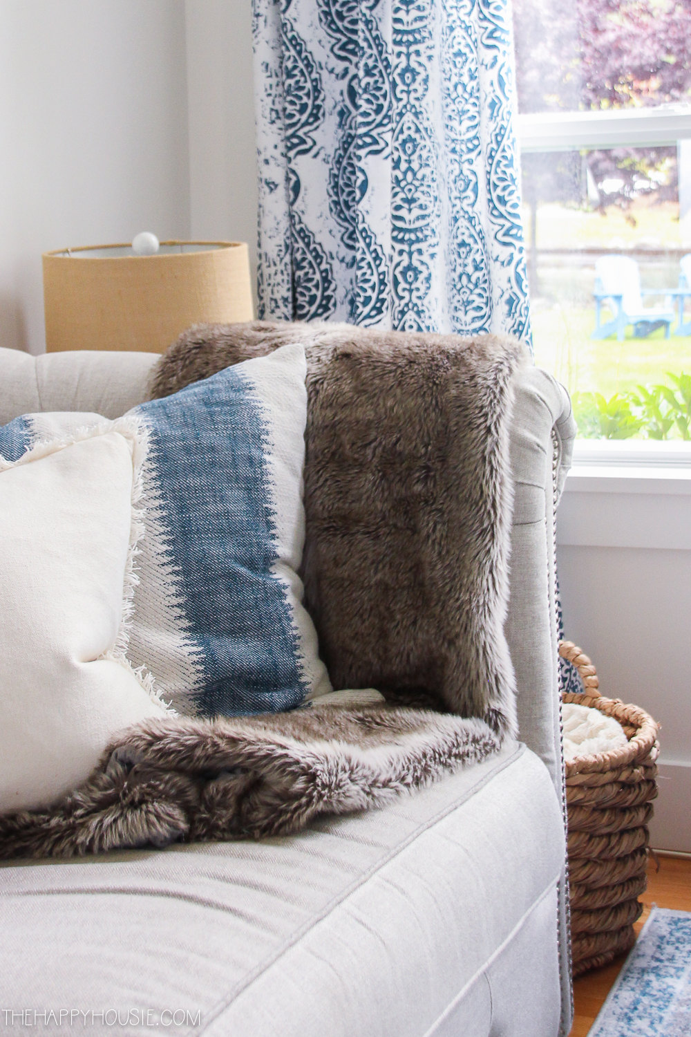 Blue and white pillows on the couch beside the faux fur throw.
