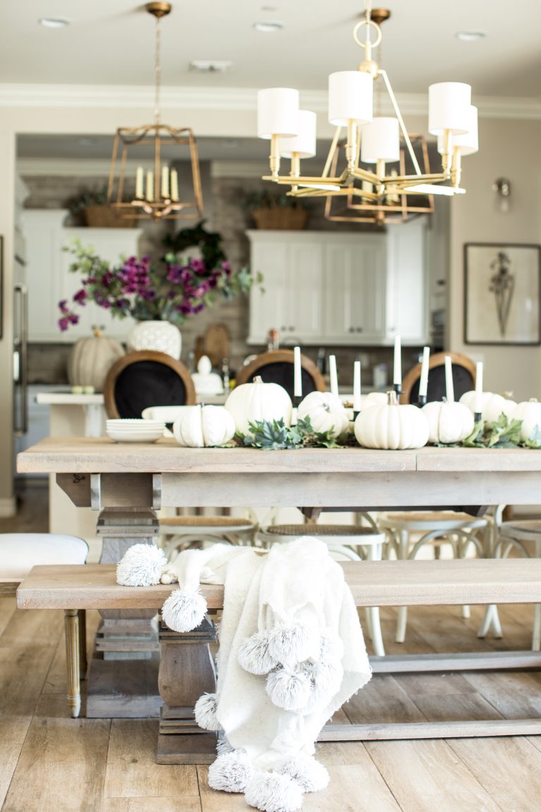 White pumpkins decorate a wooden table in the dining room.