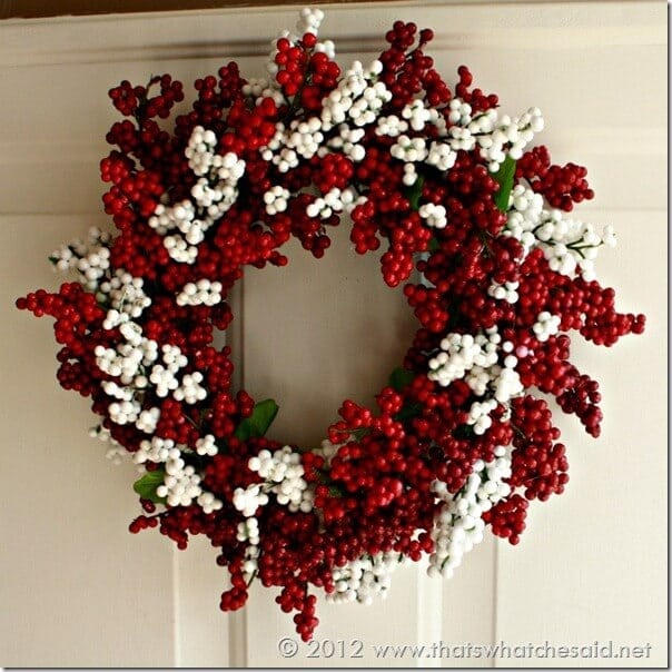 Red and white berry wreath hanging on the door.
