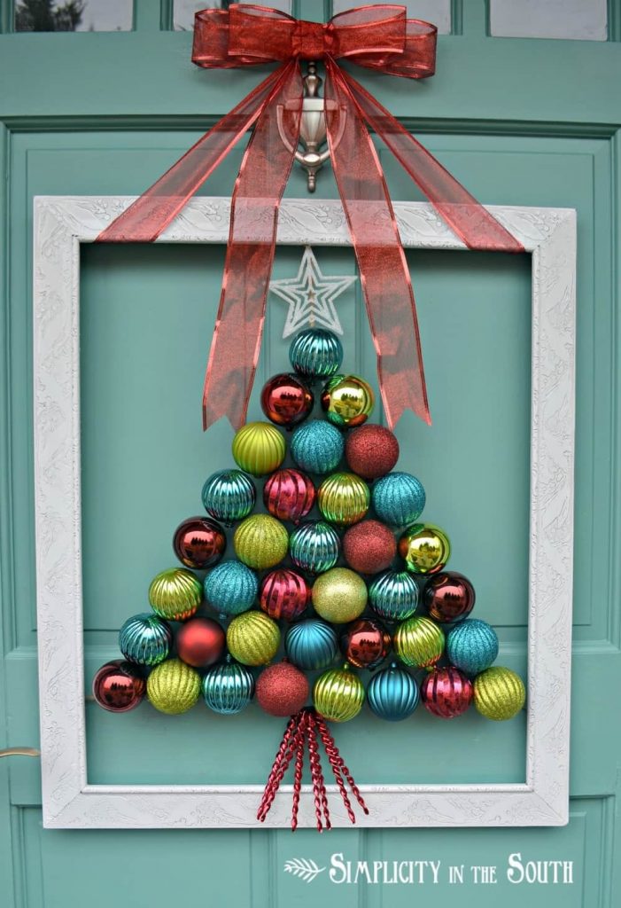 A Christmas ornament wreath with gold, blue and green ornaments.