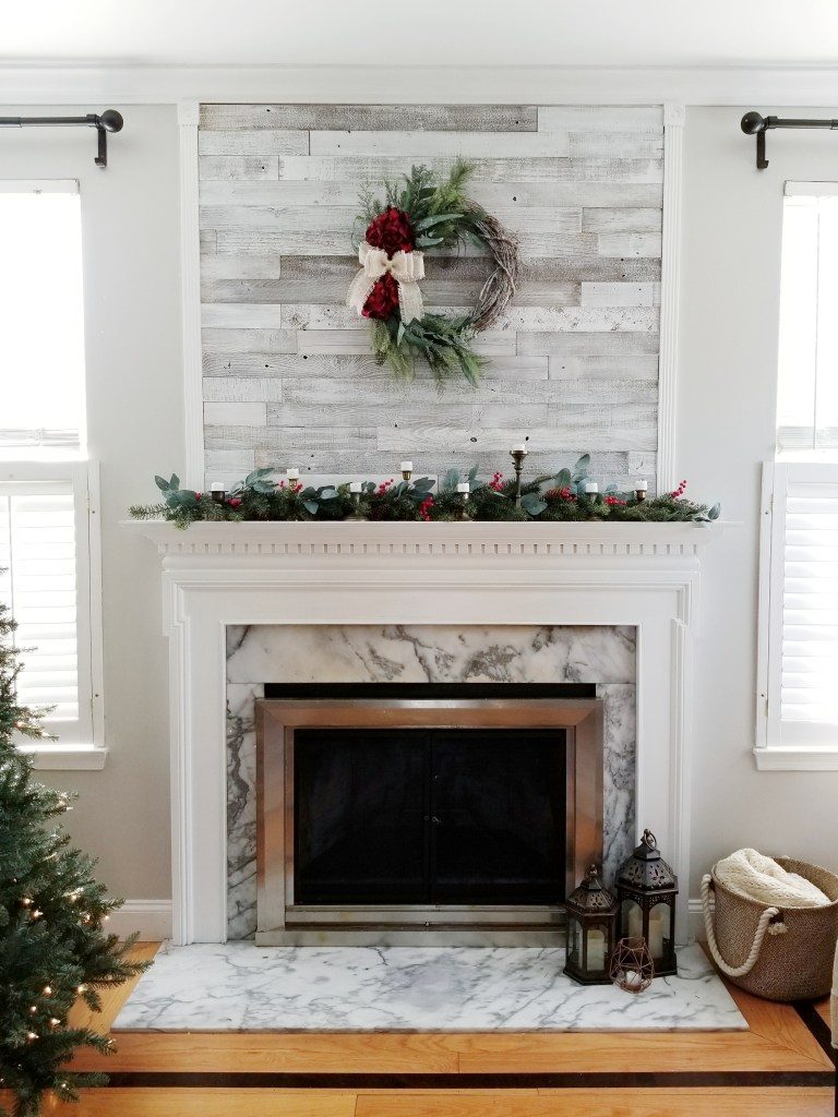 A green and red wreath hanging over the fireplace.