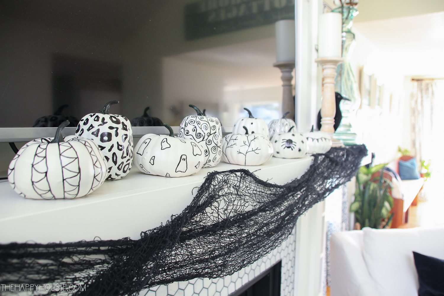 White pumpkins with black drawings on them.