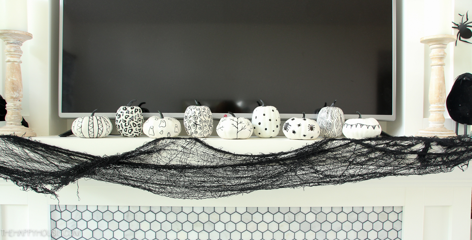 Black and white pumpkins on the mantle.
