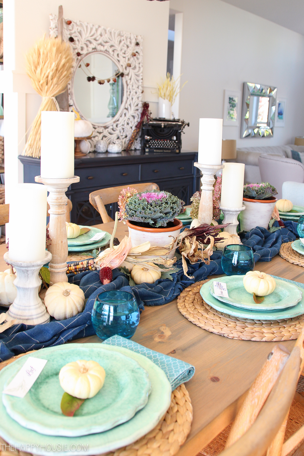 Plaid, candles, blue plates and clear blue glass on the table.