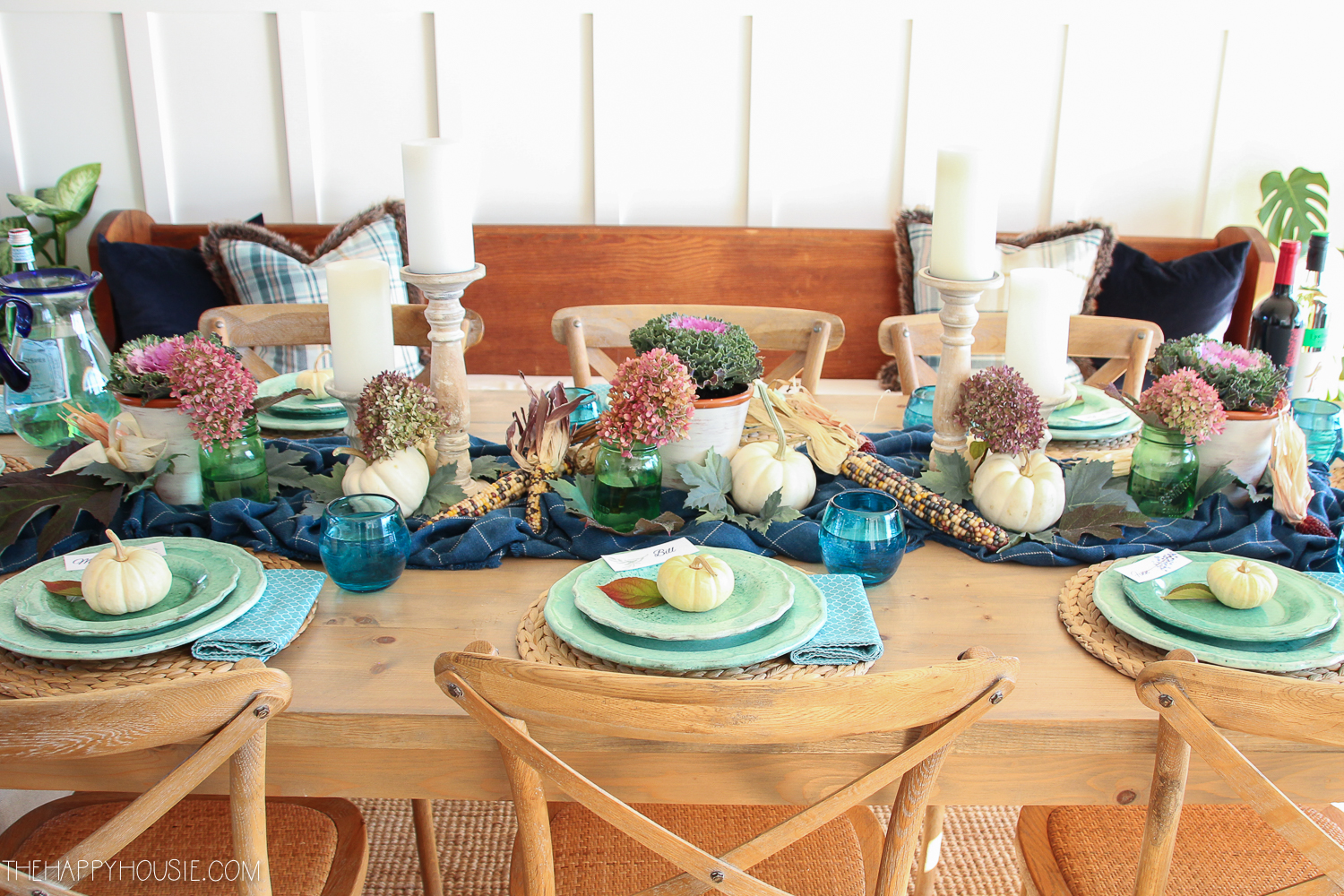 Blue plates, hydrangeas and candles are on the table.