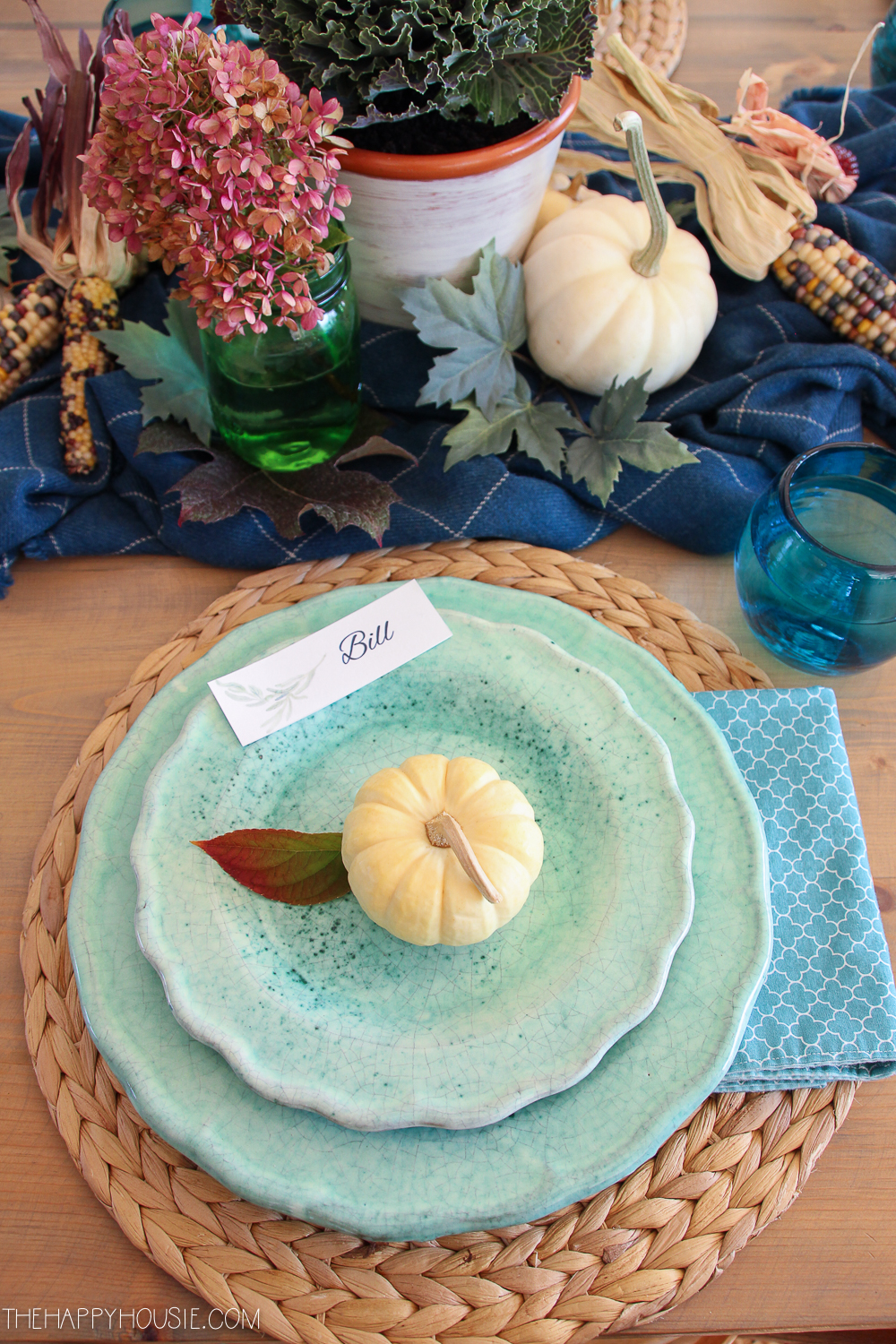 A single white mini pumpkin is in the middle of the blue plate.