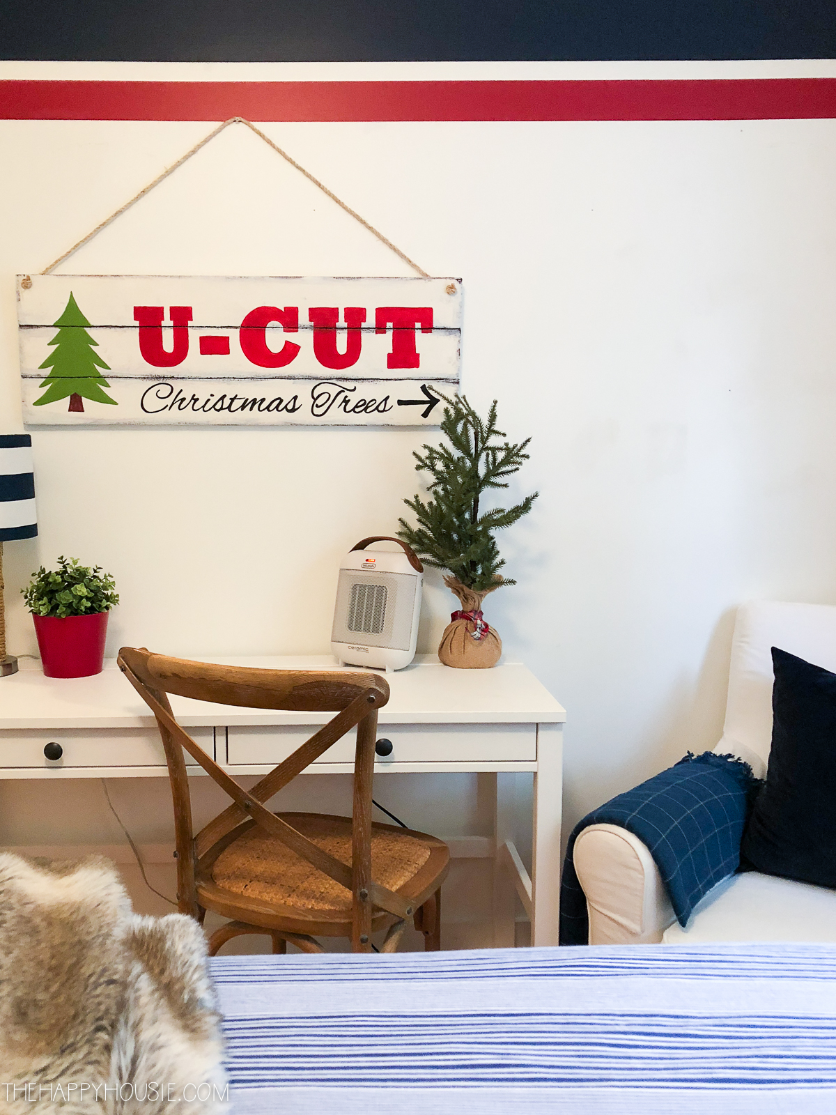 Small plant, Christmas tree, and a sign that says U-Cut Christmas Trees in the guest bedroom.