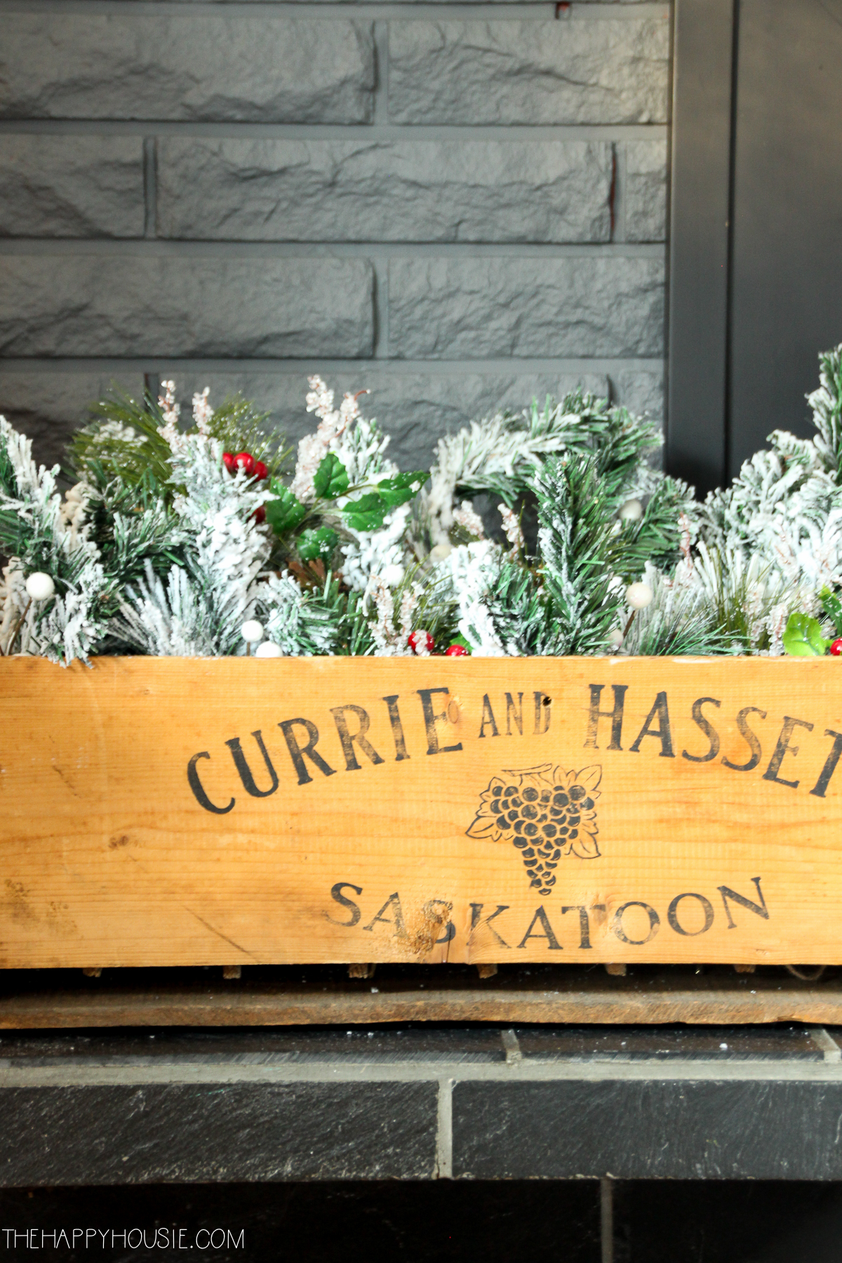 There is a Saskatoon wooden crate with greenery in it on the mantel.