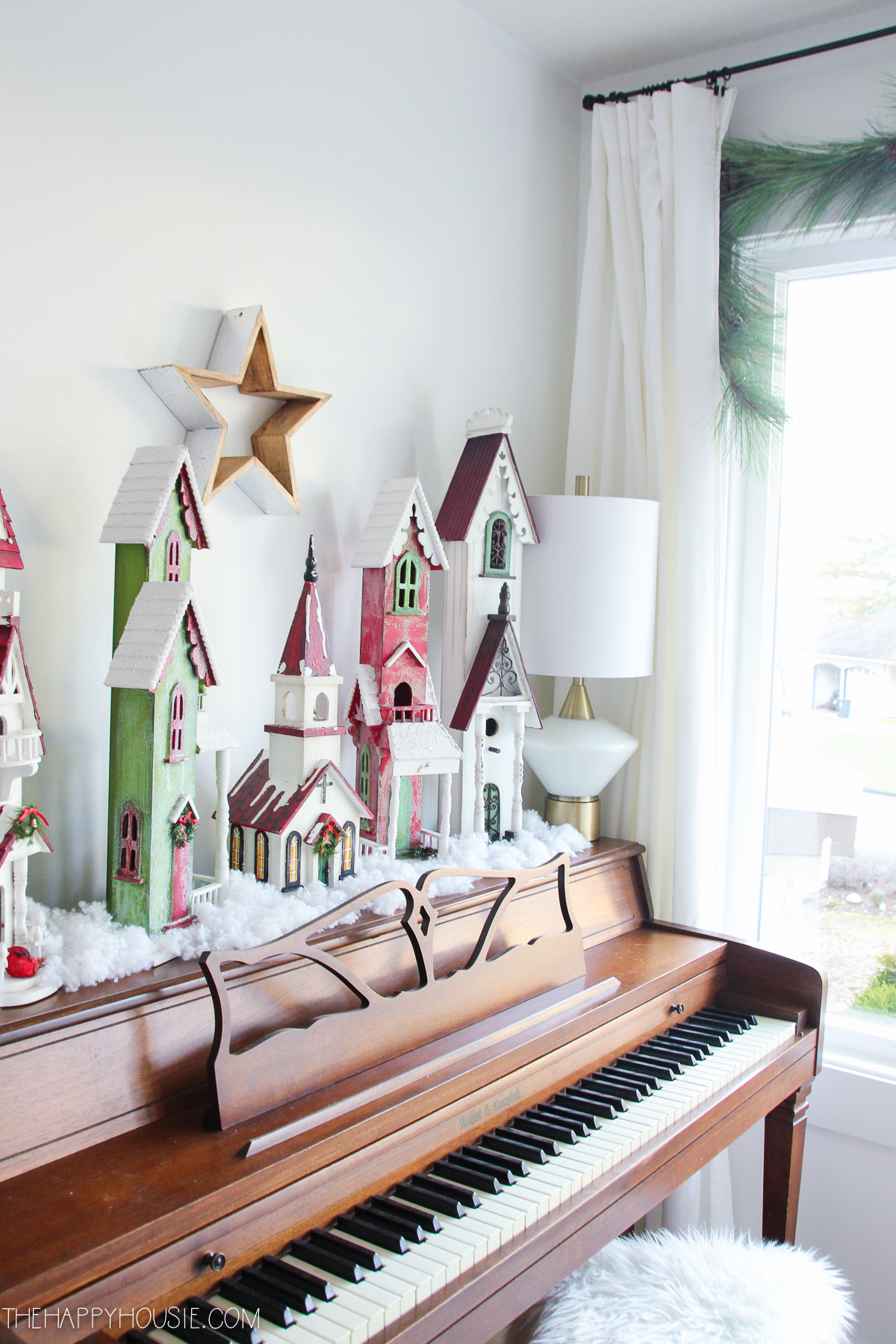 A piano with Christmas houses on it.