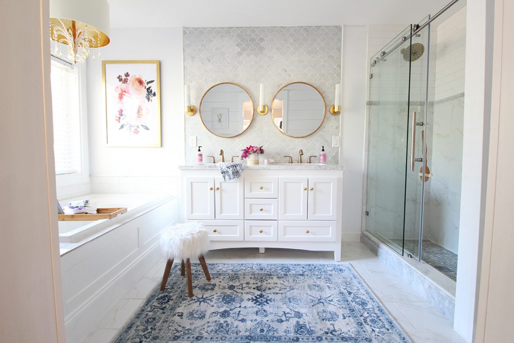 Two round gold mirrors above the bathroom vanity.