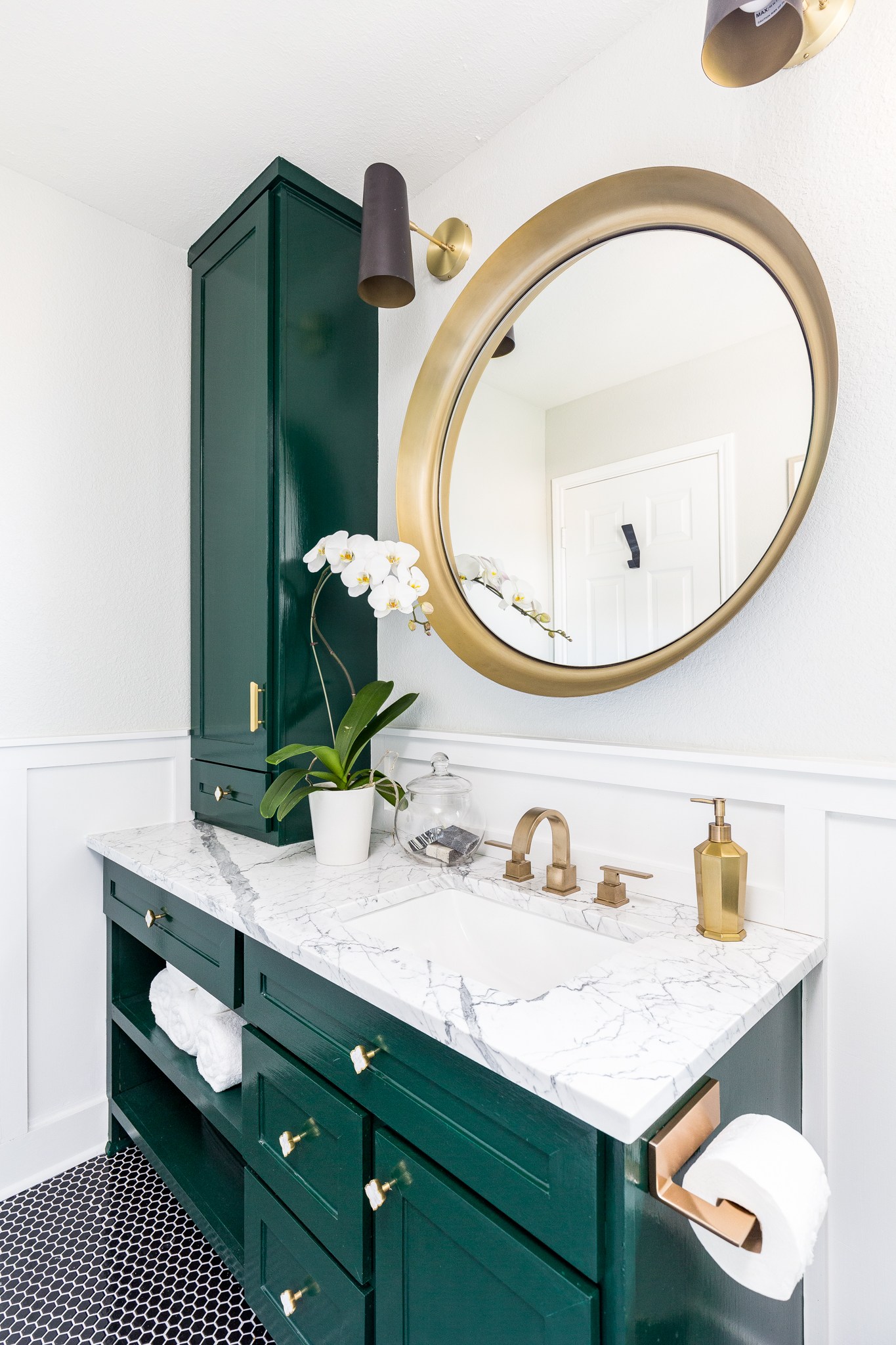 A rich turquoise cabinetry in this bathroom with gold details.