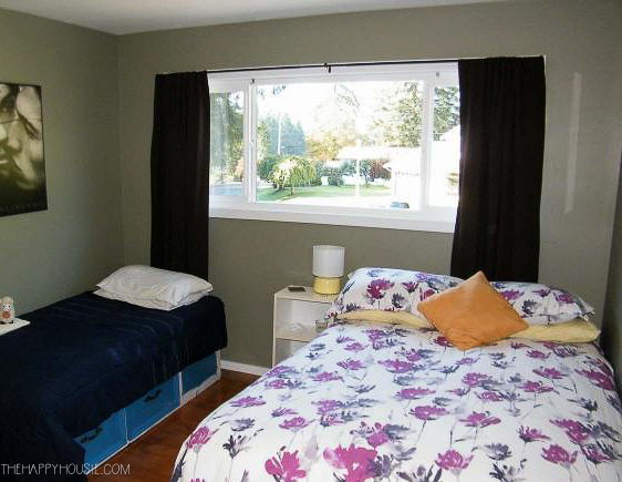 a guest bedroom with a double bed and twin bed as well as dark green walls