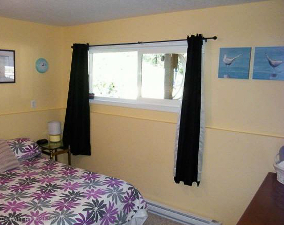 a bright yellow guest room in the basement before updating