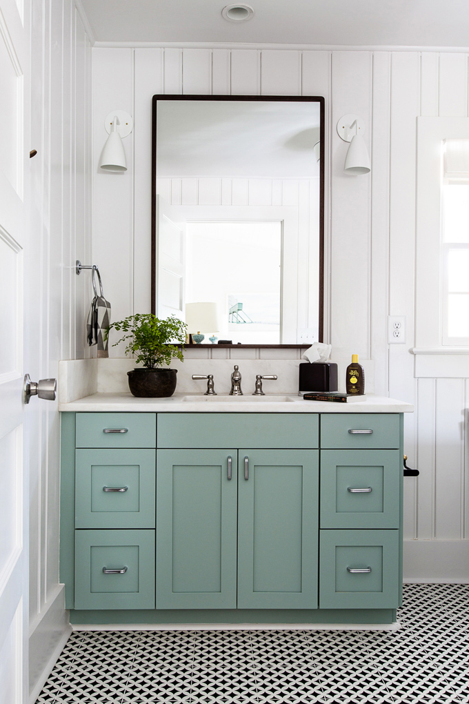 A turquoise painted vanity and tiled floor.