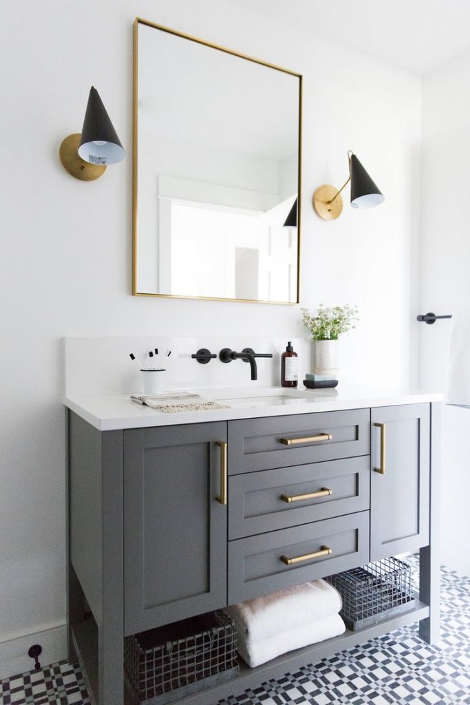Brass and gold pulls, with a square mirror in this bathroom.