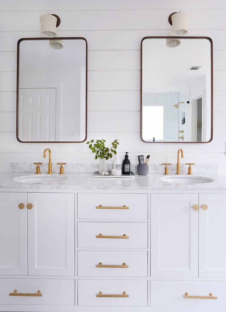 Two mirrors and two sinks with gold.