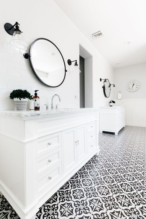 A white and black bathroom with a tile patterned floor.