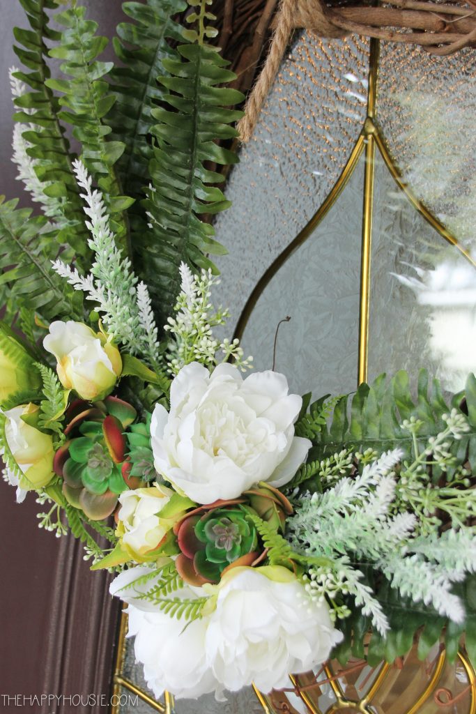 White flowers and fern wreath on the door.