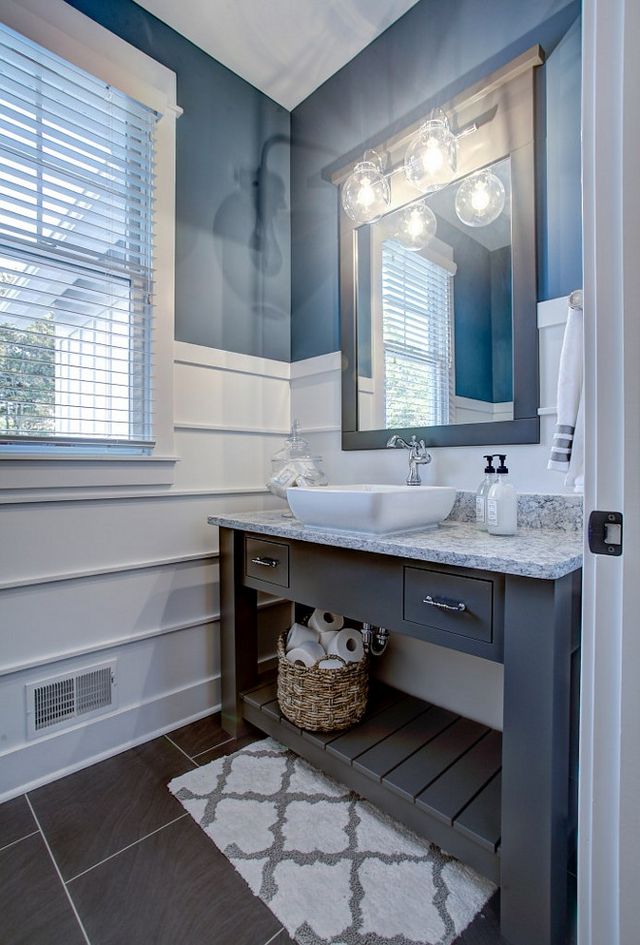 A blue and white bathroom with panelled walls.