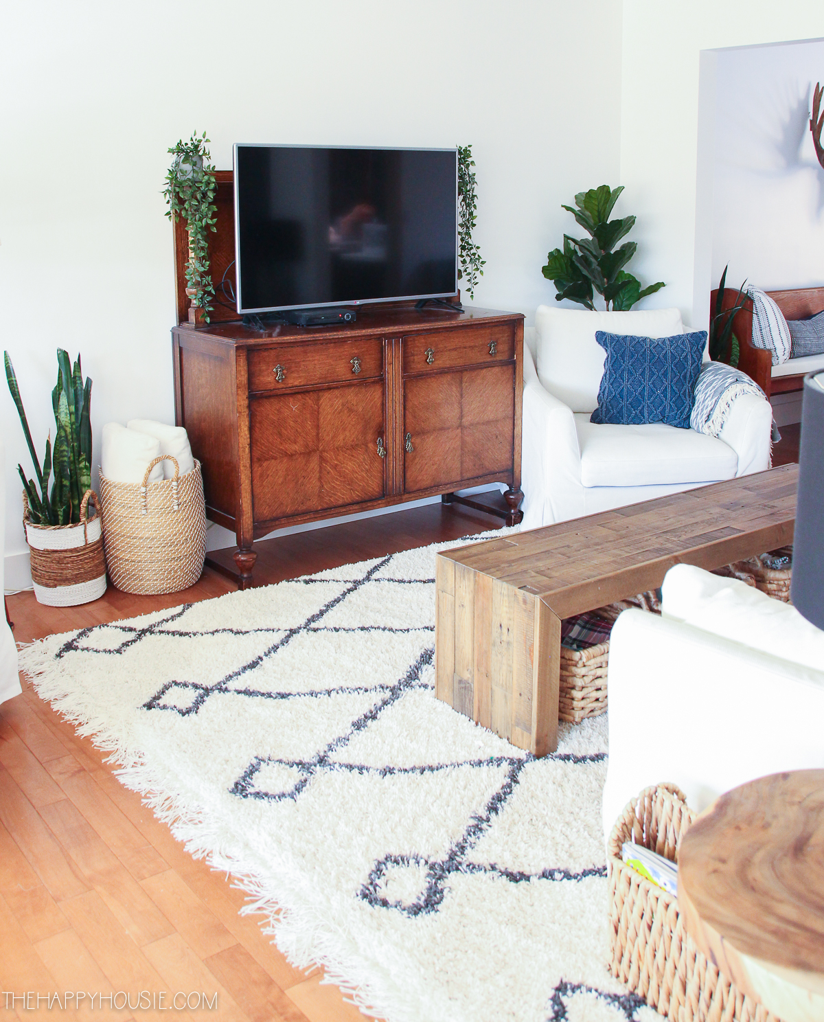A large TV is sitting on a wooden table in the living room.