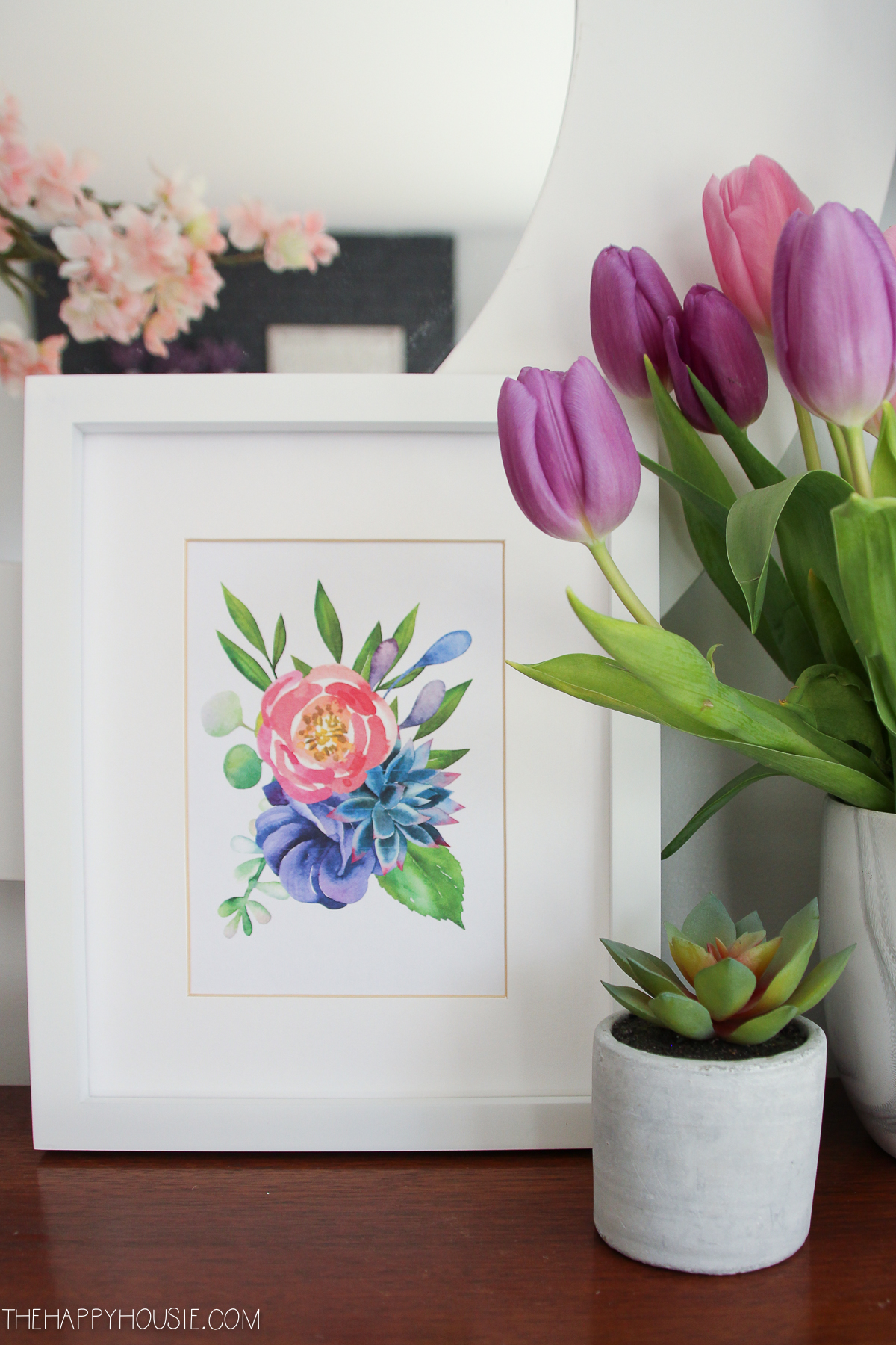A framed flower print is on the table.