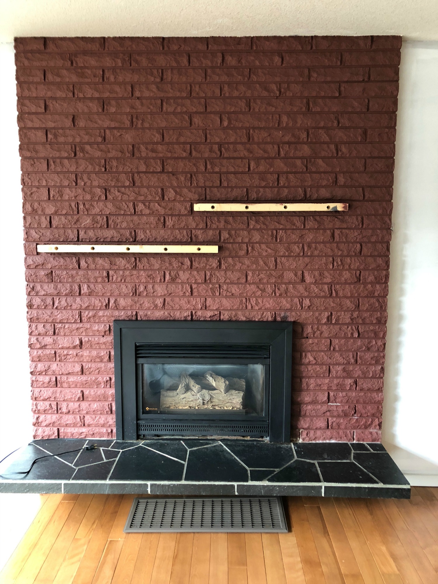 Red brick fireplace with gold shelves.
