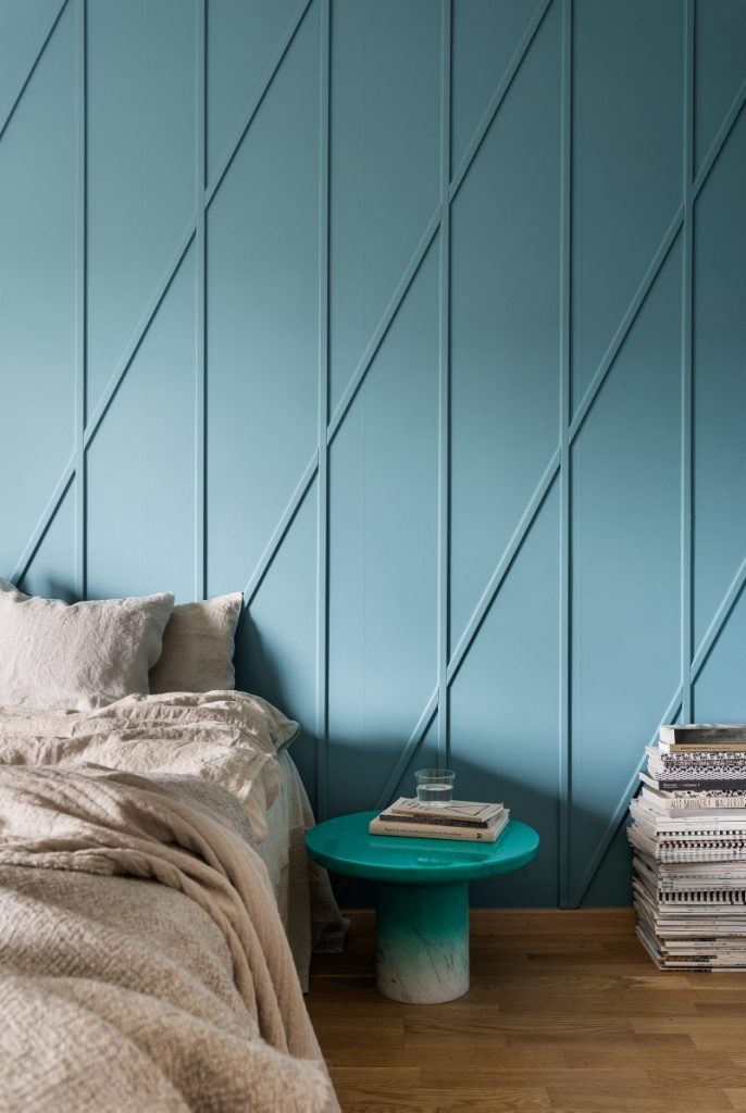 Ombre teal panelled walls in a bedroom.
