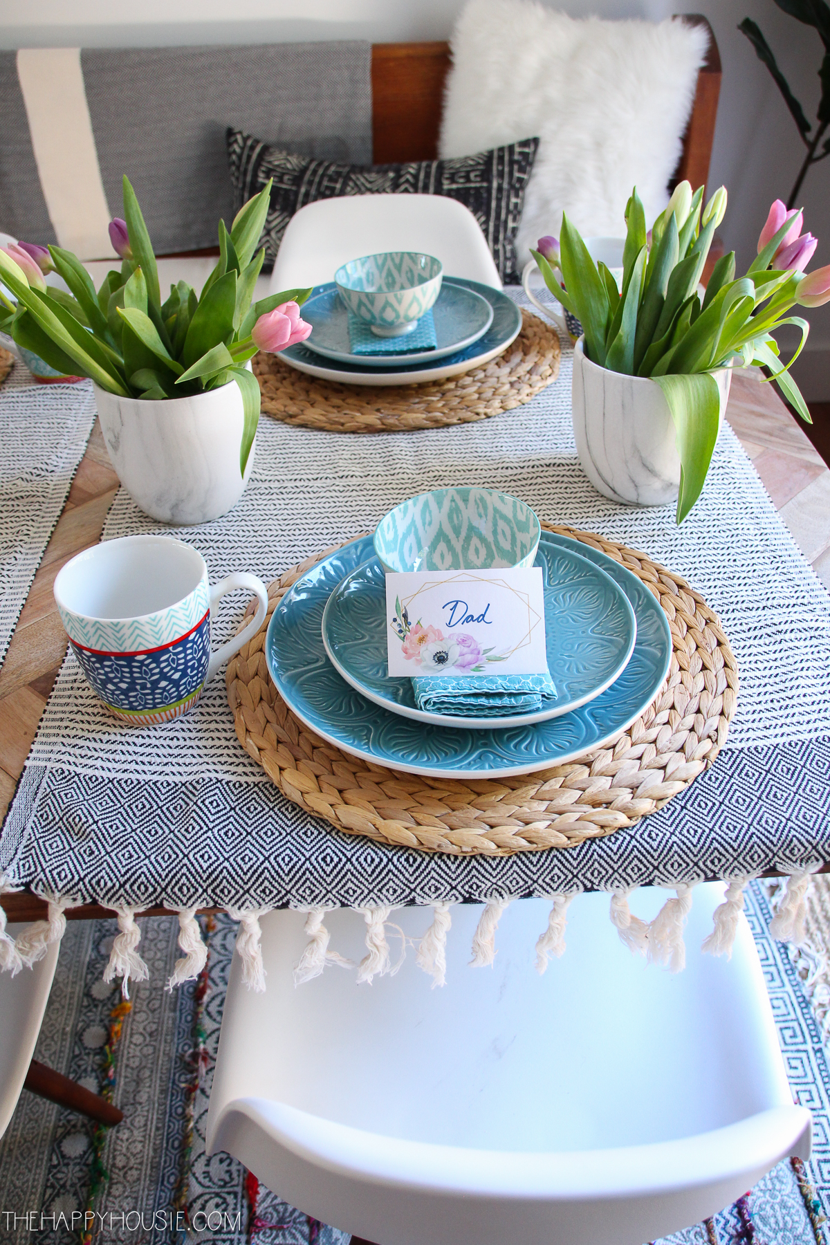 A table setting of blue plates and tulips.